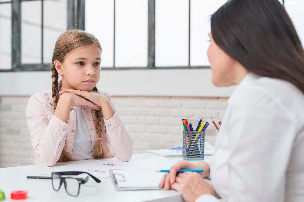 young-child-psychologist-talking-with-sad-little-girl-office_23-2148026278